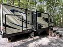 Sunset Trail RV features a sleek exterior design with steps, parked on gravel at 106 Indian Cv, Louisburg, NC 27549
