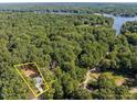 Aerial view of a home with property lines outlined, highlighting its location near a lake and woods at 107 Cochise Dr, Louisburg, NC 27549