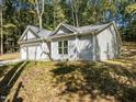 Stylish single-story home with gray siding and a well-maintained lawn and lush surrounding trees at 107 Cochise Dr, Louisburg, NC 27549