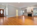 Open living room featuring hardwood floors, large windows, fireplace and views to the front entrance at 107 Helmsdale Dr, Chapel Hill, NC 27517