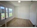 Bright bedroom featuring light wood floors, white walls, a window with a view of the neighborhood at 130 W Crescent Mills Blvd # Homesite 251, Wilson's Mills, NC 27520