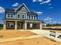 New two-story home with a two-car garage, gray siding, stone accents, and an unfinished yard at 130 W Crescent Mills Blvd # Homesite 251, Wilson's Mills, NC 27520