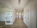 Inviting foyer featuring light wood floors, white walls, and a view into the open-concept kitchen and living area at 130 W Crescent Mills Blvd # Homesite 251, Wilson's Mills, NC 27520