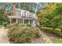 Quaint home featuring a welcoming front porch, complemented by lush greenery and mature trees at 1316 Raybon Dr, Wendell, NC 27591