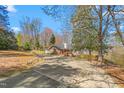 Spacious lot featuring an attractive brick home with a circular driveway, carport, and lush surrounding greenery at 1405 N Sellars Mill Rd, Burlington, NC 27217