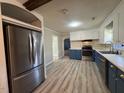 Well-lit kitchen with stainless steel appliances, new flooring, and two-tone cabinets at 1618 Gerringer Mill Rd, Burlington, NC 27217