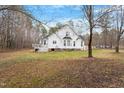Extensive backyard showing mature trees, a deck, concrete patio, and lush green space at 173 Allie Dr, Garner, NC 27529