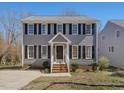 Traditional two-story home with gray exterior, black shutters, and inviting front porch at 1961 Indianwood Ct, Raleigh, NC 27604