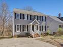 Inviting two-story home with gray siding, black shutters, and well-maintained landscape at 1961 Indianwood Ct, Raleigh, NC 27604