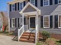 Close-up of the home's entry featuring a brick staircase and a classic black front door at 1961 Indianwood Ct, Raleigh, NC 27604