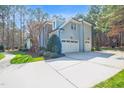 Exterior view of attached garage, manicured lawn, and stone-accented facade at 204 Dartmoor Ln, Raleigh, NC 27614