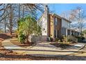 Two-story home with brick and gray siding, a fenced yard, mature trees, and a paved walkway at 205 Clancy Cir, Cary, NC 27511