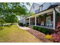 Inviting front porch featuring stone accents, comfortable seating, and manicured landscaping at 222 Friesan Way, Rolesville, NC 27571