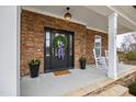 Detailed view of the front porch, featuring a wreath, rocking chairs, stone accents and planters at 222 Friesan Way, Rolesville, NC 27571