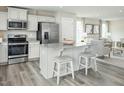 Modern kitchen featuring stainless steel appliances, a center island with seating, and ample natural light at 26 Artesa Ct, Fuquay Varina, NC 27526