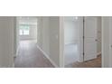 Open hallway with wood flooring leading to bedrooms with neutral carpet and ample natural light at 267 Palm Dr, Sanford, NC 27332