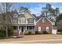Classic two-story home with a covered front porch and mature trees in a well-manicured front yard at 3659 Coach Lantern Ave, Wake Forest, NC 27587
