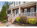 Inviting front porch with white railings and brick accents, offering curb appeal and charm at 3659 Coach Lantern Ave, Wake Forest, NC 27587