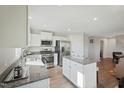 Bright kitchen featuring a central island, stainless appliances, and ample white cabinetry at 37 Artesa Ct, Fuquay Varina, NC 27526