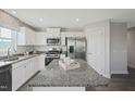Modern kitchen features granite countertops, stainless steel appliances, and a kitchen island at 37 Artesa Ct, Fuquay Varina, NC 27526