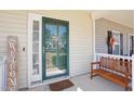 Close-up of a cheerful front porch, complete with a 'Welcome' sign and a quaint wooden bench at 3809 Volkswalk Pl, Raleigh, NC 27610