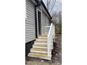 Side door entryway with new wood stairs and white railing to make the entryway accessible and safe at 471 Merriman St, Henderson, NC 27536