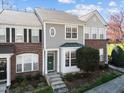 Two story townhome with manicured lawn and garden and a welcoming green front door at 5333 Crescentview Pkwy, Raleigh, NC 27606