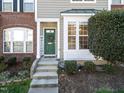 A townhome featuring a welcoming green front door with a green wreath and a green covered awning at 5333 Crescentview Pkwy, Raleigh, NC 27606