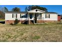 Quaint single-story home featuring a covered front porch and well-maintained lawn at 59 Willow Lake Rd, Roxboro, NC 27574