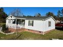 Charming single-story house with a brick foundation and white siding at 59 Willow Lake Rd, Roxboro, NC 27574