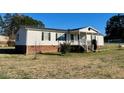 Inviting single-story home with a brick foundation and neat landscaping at 59 Willow Lake Rd, Roxboro, NC 27574