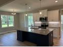 Bright kitchen featuring an island with granite countertops, stainless steel appliances, and views to the yard at 70 Prency Ln, Middlesex, NC 27557