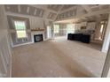 Spacious living room featuring a fireplace, large windows, and an open floor plan to the kitchen at 70 Prency Ln, Middlesex, NC 27557