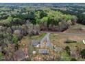 Property aerial shows long driveway access, metal outbuildings, and expansive woods at 765 Townsville Landing Rd, Henderson, NC 27537