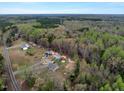 Aerial view showcases the property surrounded by lush greenery and mature trees at 765 Townsville Landing Rd, Henderson, NC 27537