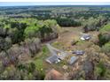 Aerial view of home with long driveway, metal outbuildings, and wooded surroundings at 765 Townsville Landing Rd, Henderson, NC 27537