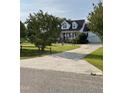 Traditional two-story home with a long driveway, manicured lawn, and mature trees at 100 Blackberry Creek Dr, Willow Springs, NC 27592