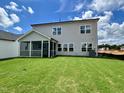 A spacious backyard with green lawn, screened patio and gray siding, perfect for outdoor living at 108 N Stonemill Trl # Homesite 254, Wilson's Mills, NC 27520