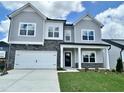 Charming two-story home with gray siding, stone accents, manicured lawn and attached two car garage at 108 N Stonemill Trl # Homesite 254, Wilson's Mills, NC 27520