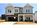 Newly constructed two-story home featuring gray siding, stone accents, and an attached two-car garage at 108 N Stonemill Trl # Homesite 254, Wilson's Mills, NC 27520