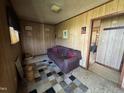 Cozy living room features wood paneling, plush sofa, and a patterned area rug at 113 Smith St, Four Oaks, NC 27524