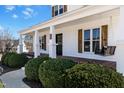 Inviting front porch with wood decking, stylish columns, decorative shutters, and a swing at 118 Riverwood Dr, Fuquay Varina, NC 27526