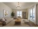 Cozy living room with neutral-toned furniture, a modern chandelier, and ample natural light at 118 Riverwood Dr, Fuquay Varina, NC 27526