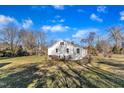 Rear view of home with basement access and large backyard under a beautiful blue sky at 152 E Tryon St, Hillsborough, NC 27278