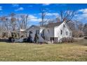 View of the rear of the house with a well-maintained lawn and mature trees at 152 E Tryon St, Hillsborough, NC 27278