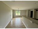 Open dining area with hardwood floors, modern chandelier and breakfast bar at 186 N Movado Trl, Kenly, NC 27542