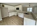 Well-appointed kitchen with white cabinets, granite counters, stainless microwave, and hardwood floors at 186 N Movado Trl, Kenly, NC 27542