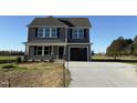 Charming two-story home featuring gray siding, black shutters, a covered porch, and a two-car garage at 22 Wynd Crest Way, Benson, NC 27504
