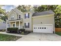 Inviting home with a manicured lawn and a two-car garage, surrounded by mature trees at 2208 Woodbury Dr, Hillsborough, NC 27278