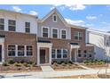 Charming brick townhouse featuring a modern exterior and manicured landscaping at 256 Chesapeake Commons St # 157, Garner, NC 27529
